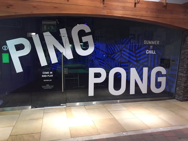 A large format printing design is displayed on a glass door and panel 