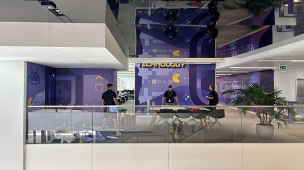 Custom wall graphics displayed across the walls of a modern technology-focused commercial interior. 