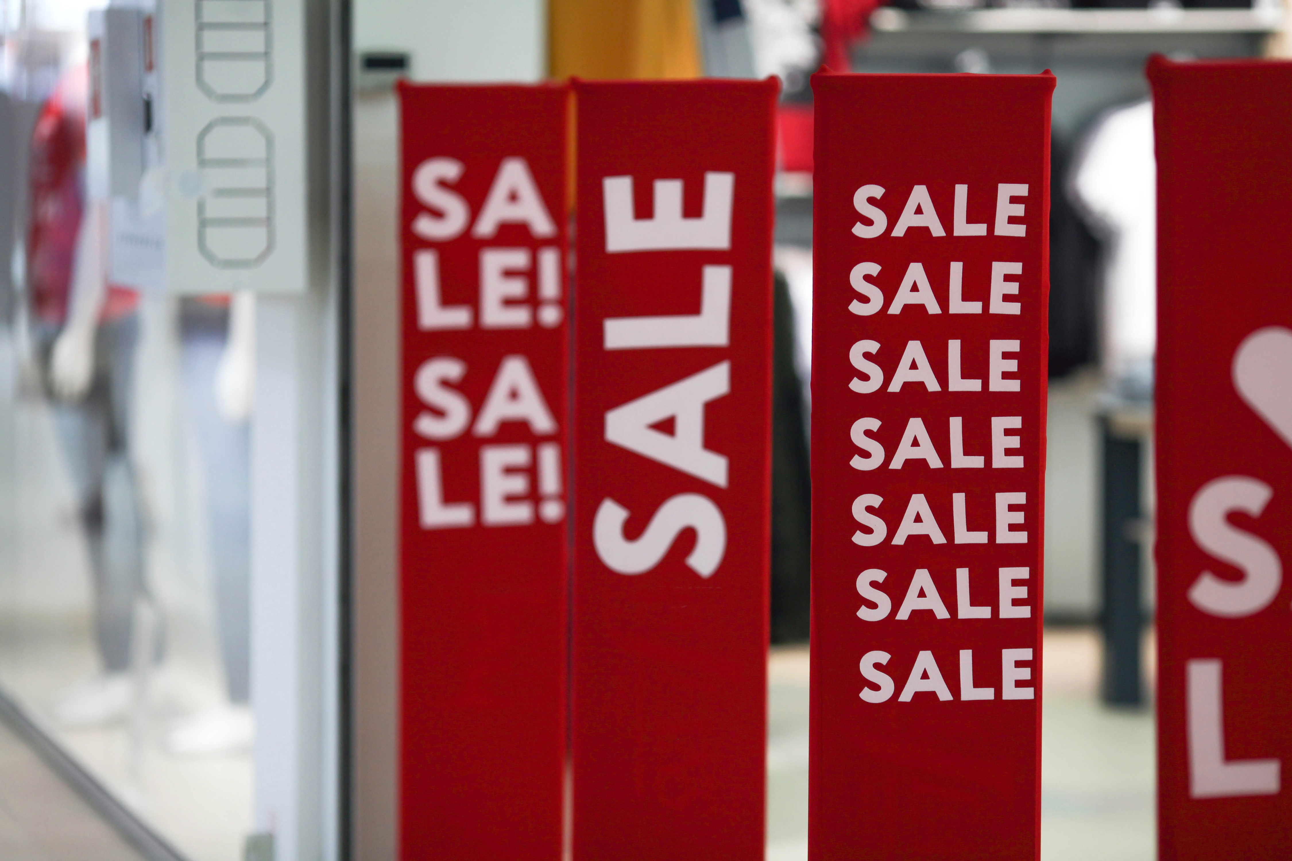 Bold red sale banners displayed outside retail shops created with high-impact large format printing.