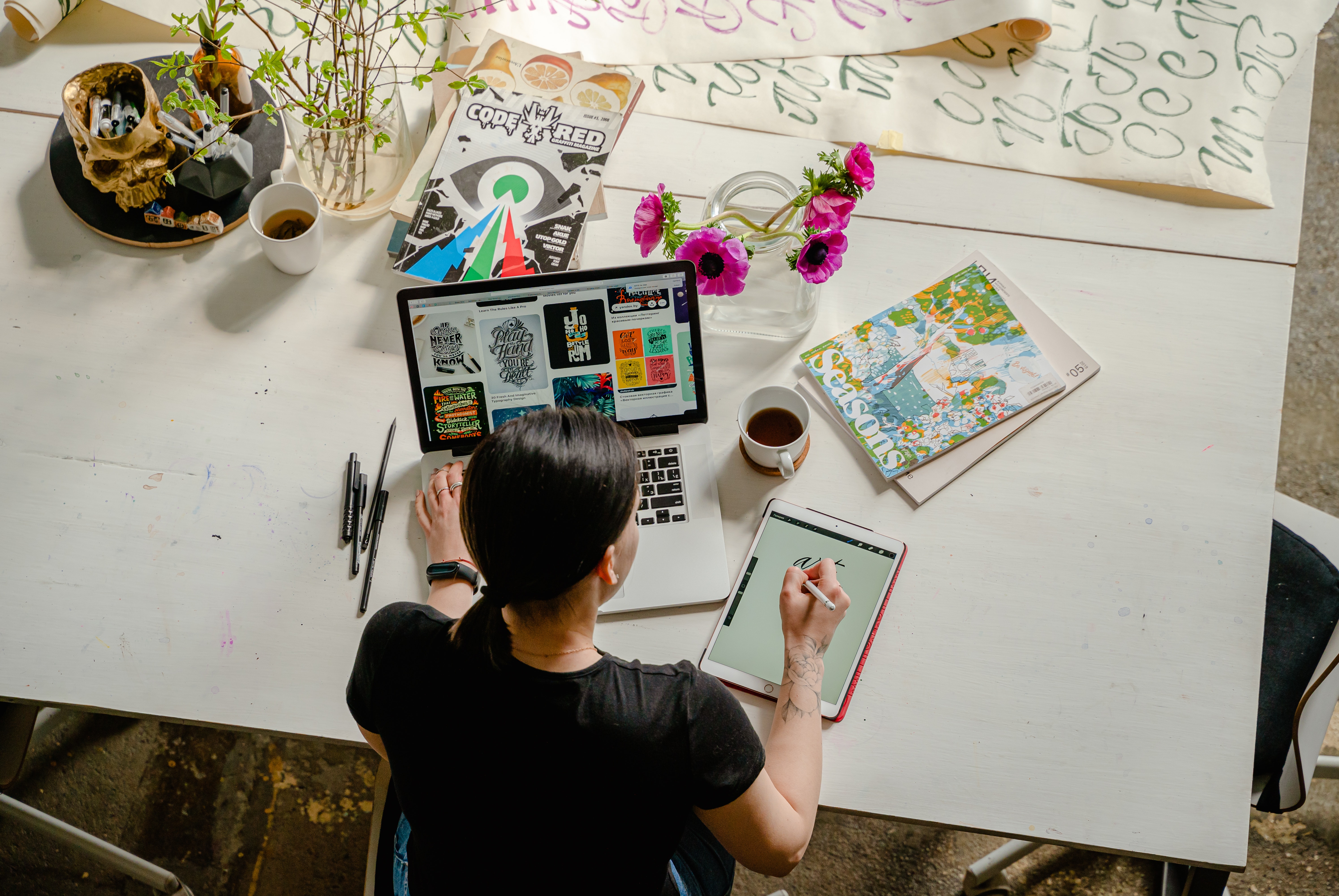 woman on laptop and tablet creating digital prints to show why you should invest in high quality digital prints